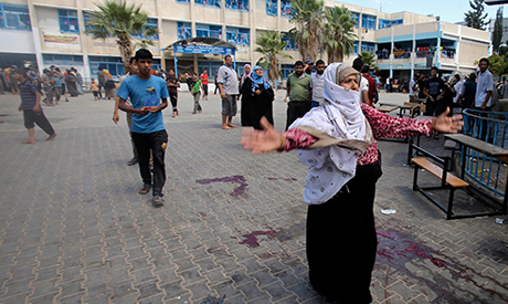 A Palestinian woman reacts as the blood of wounded and dead people is seen on the ground following what witnesses said was an Israeli air strike at a United Nations-run school, where displaced Palestinians take refuge, in Rafah in the southern Gaza Strip August 3, 2014 (Photo: Reuters) 