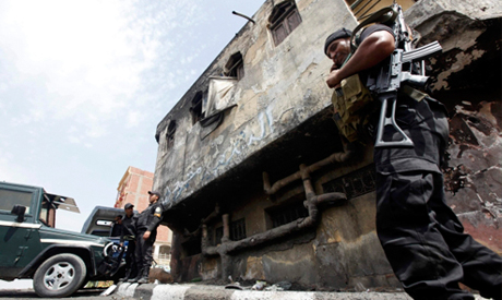Police officers stand in front of a damaged police station in the village of Kerdasa (Photo: Reuters) 