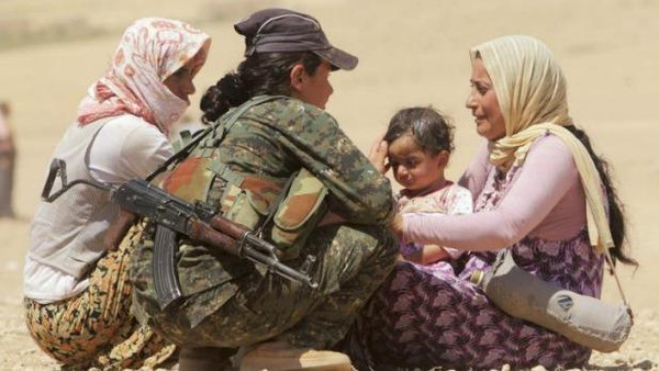  Displaced people from the minority Yazidi sect speak with a Kurdish fighter near the border between Iraq and Syria’s Hasaka province. (File photo: Reuters) 
