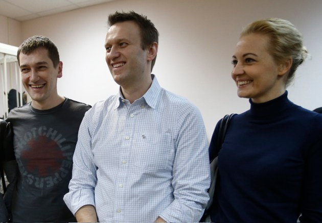 Russian opposition activist and anti-corruption crusader Alexei Navalny, 38, center, his wife Yulia and his brother Oleg Navalny smile at a court in Moscow on Dec. 30, 2014.