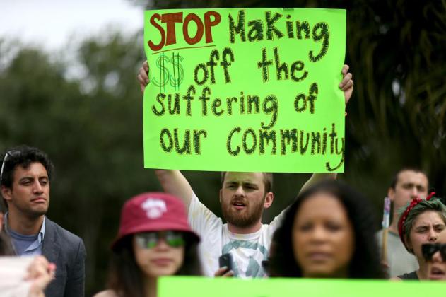BOCA RATON, FL - MAY 04: Protesters gather in front of the GEO Group headquarters to speak out against the company that manages private prisons across the United States on May 4, 2015 in Boca Raton, Florida. The protesters are condemning what they say are the companies active lobbying efforts to criminalize and imprison immigrants and people of color and then to make a profit off their imprisonment. (Photo by Joe Raedle/Getty Images)