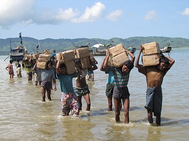 Displaced Rohingya unload provisions from a boat. Image Credit: Mathias Eick, EU/ECHO