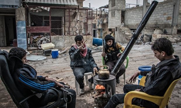 A group of rebel fighters sit around a fire in Aleppo. Photograph: Karam Almasri/NurPhoto/Rex Features