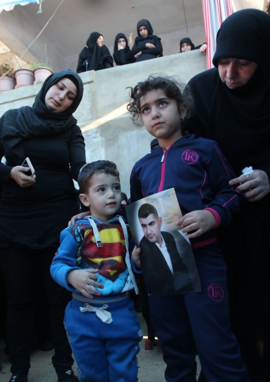  Ali and Malak, the children of Adel Termos, who was killed in a twin bombing attack that rocked a busy shopping street in the area of Burj al-Barajneh in Beirut’s southern suburb, carry a portrait of their father during his funeral in the village of Tallussa in the Nabatiyeh governorate, south of Lebanon, on Nov. 13, 2015. (Mahmoud Sayyat/AFP/Getty Images) 